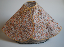 Een katoenen kapmanteltje met een dessin van allemaal bloemetjes in herfstkleuren.