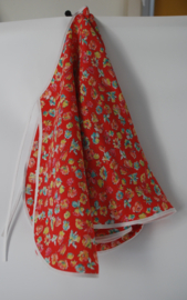 Een vrolijk, soepel vallend kapmanteltje van viscose met kleine bloemetjes op een licht rode ondergrond.