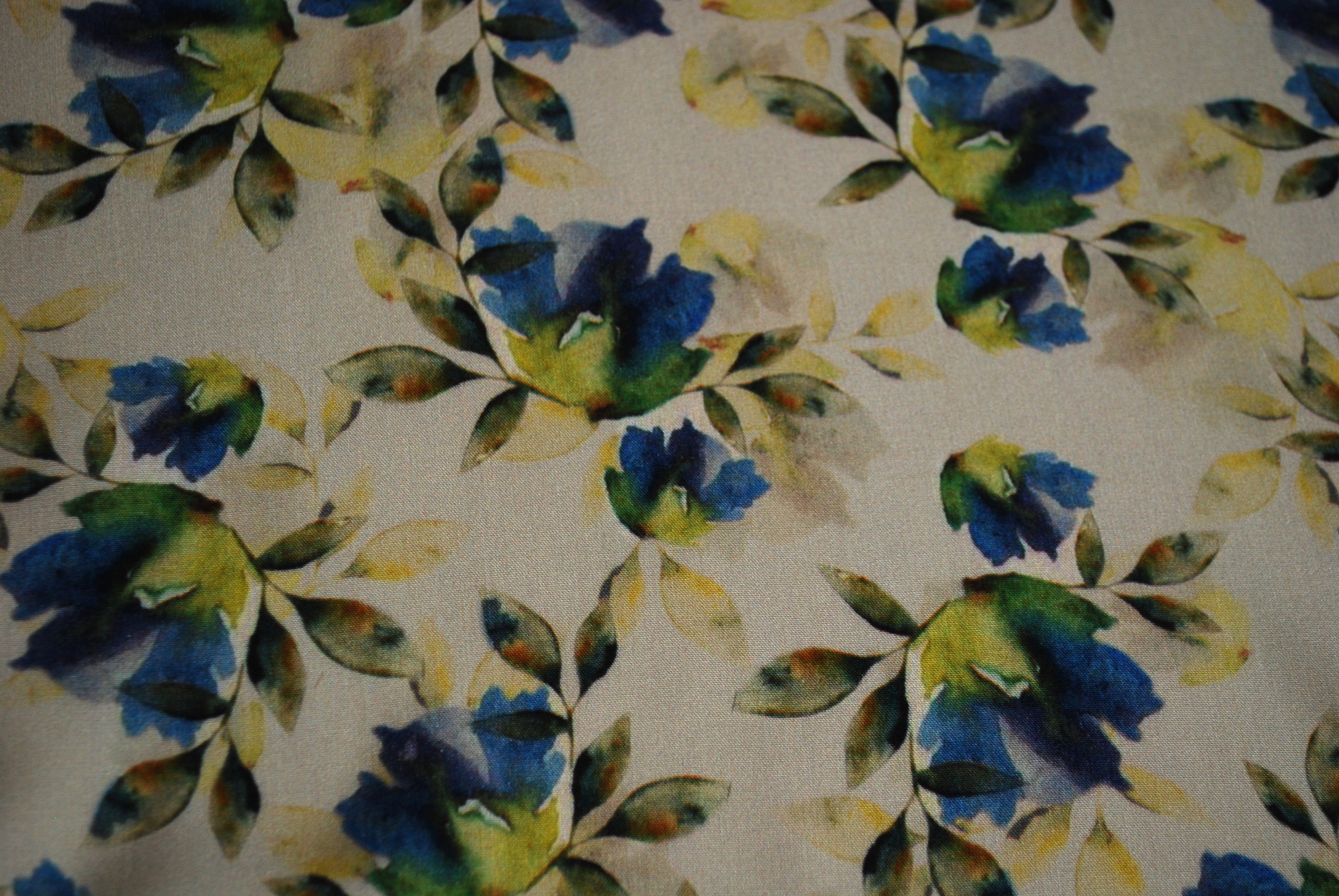 Een kapmanteltje van viscose met een boeketje van blauwe bloemen.