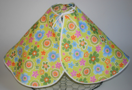 Een katoenen kapmanteltje met bloemen in diverse kleuren op een appeltjeskleurige ondergrond.