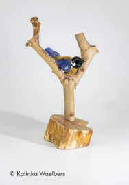 Glazen beeld: koolmeesje van glas op tak