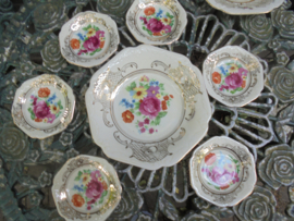 Petit foursetje met groot bloemboeket met oa roze roos en veel gouddecoratie