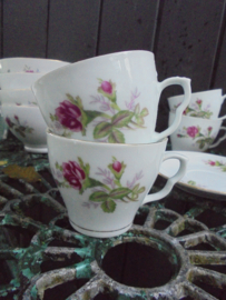 Koffie kop en schotel met wilde roze struik roos