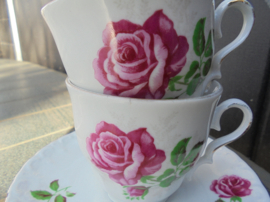 Kop en schotel met grote roze roos en sierlijk randje
