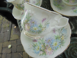 Kop en schotel met pastel bloemboeket