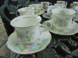 Kop en schotel met pastel bloemboeket