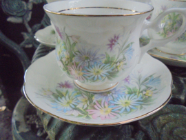 Kop en schotel met pastel bloemboeket