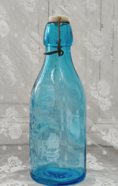 Oude melkfles met reliëf plaatje