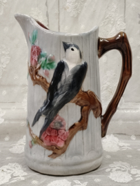 Oude barbotine kan, vogel op tak