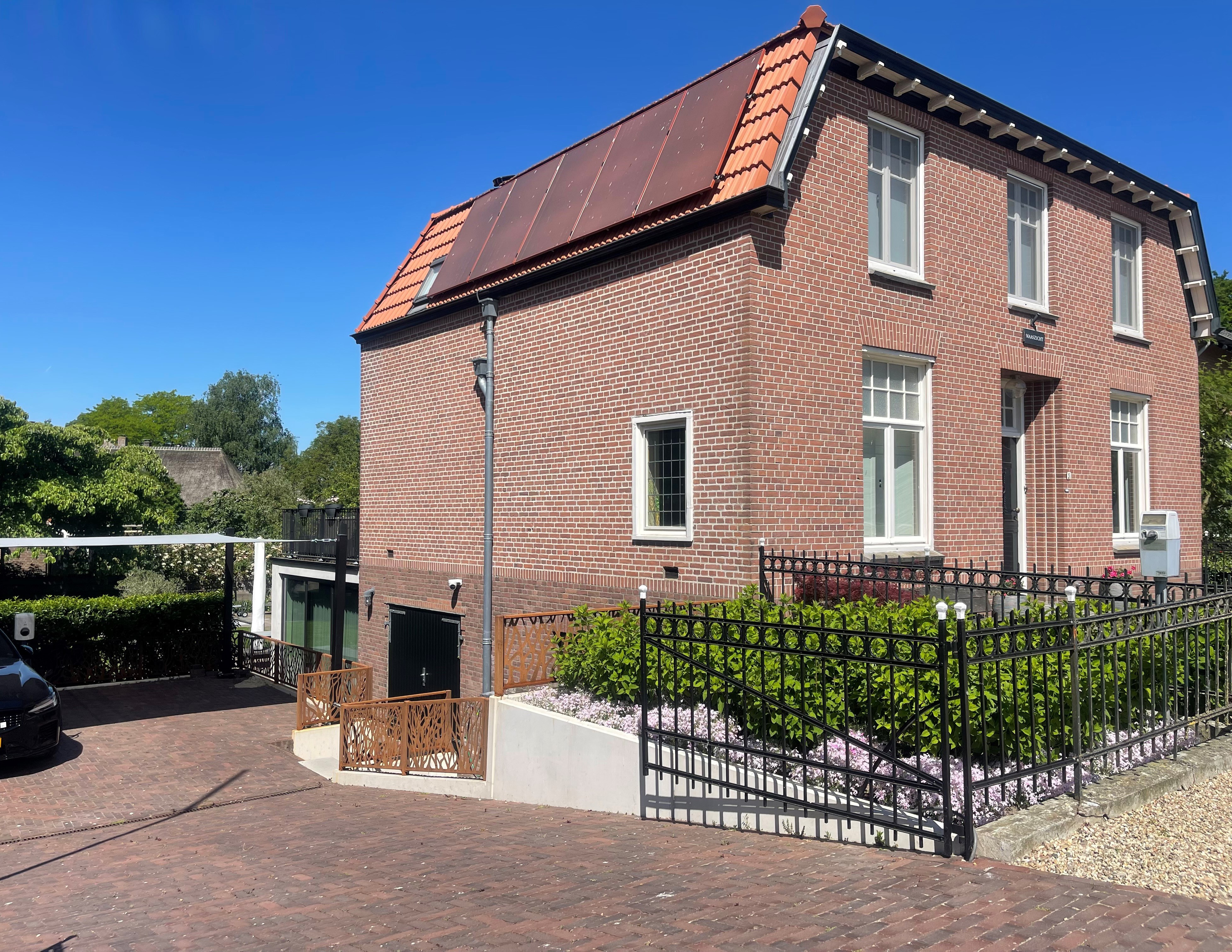 Sierhekwerk cortenstaal met boommotief bij Villa Maaszicht