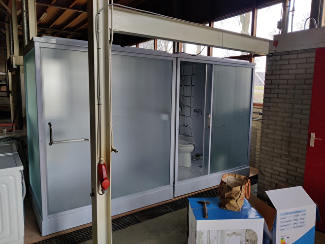 Front view of two Grand Move mobile bathrooms in the refugee shelter near Alphen a/d Rijn.