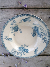 Oud bord met blauwe bloemen.