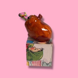 Cavia van keramiek met een feesttoeter