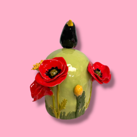 Kleine urn met bloemen en merel