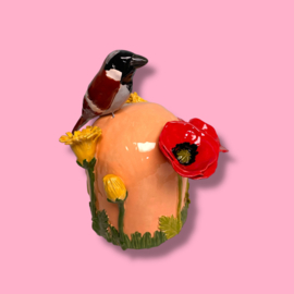 Kleine urn met bloemen en mus