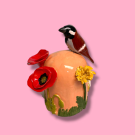 Kleine urn met bloemen en mus