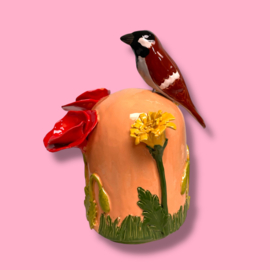 Kleine urn met bloemen en mus