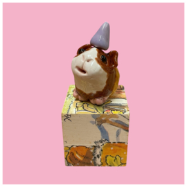 Cavia van keramiek met een feestmuts
