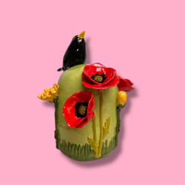Kleine urn met bloemen en merel