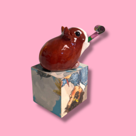 Cavia van keramiek met een feesttoeter