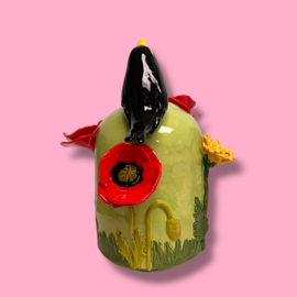 Kleine urn met bloemen en merel