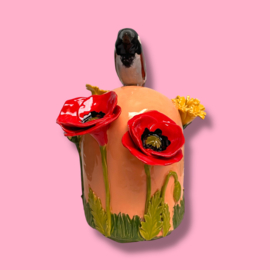 Kleine urn met bloemen en mus