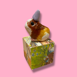 Cavia van keramiek met een feestmuts