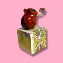 Cavia van keramiek met een feesttoeter