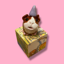 Cavia van keramiek met een feestmuts