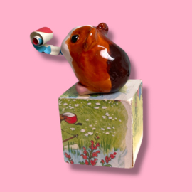 Cavia van keramiek met een feesttoeter