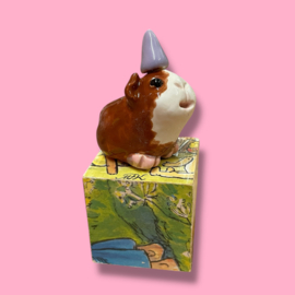 Cavia van keramiek met een feestmuts