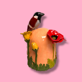 Kleine urn met bloemen en mus