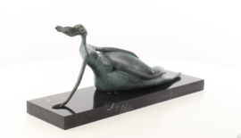 Een abstract bronzen beeld van een liggende naakte vrouw