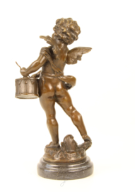 Bronzen beeld van putto spelend op zijn drum.