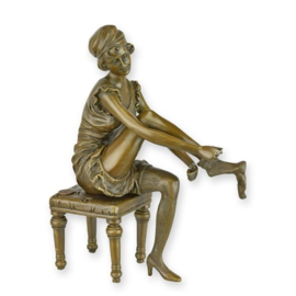 bronzen beeld van een vrouw die een panty aantrekt