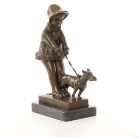 Een bronzen beeld van een jong meisje die haar hond uitlaat