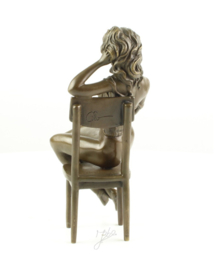 Bronzen Beeld van halfnaakte vrouw op stoel.