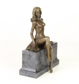 Een bronzen sculptuur van een deels naakte vrouw.