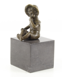 een bronzen meisje zittend op een marmeren sokkel