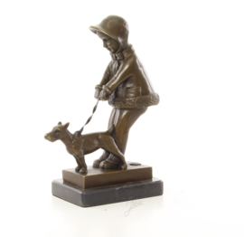 Een bronzen beeld van een jong meisje die haar hond uitlaat