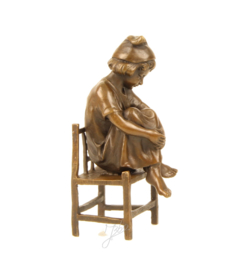 Schattig Bronzen beeldje meisje op de stoel.