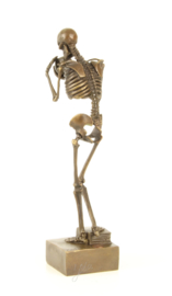 EEN BRONZEN BEELD VAN EEN SKELET MET EEN SCHEDEL