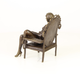 Bronzen beeld jonge erotische dame in pauwstoel
