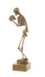 EEN BRONZEN BEELD VAN EEN SKELET MET EEN SCHEDEL