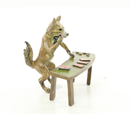 Een bronzen beeld van een vos met speelkaarten