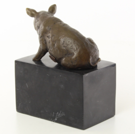 Een bronzen beeld van een zittende varken