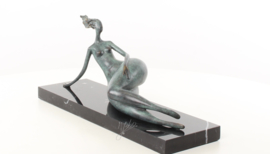 Een abstract bronzen beeld van een liggende naakte vrouw