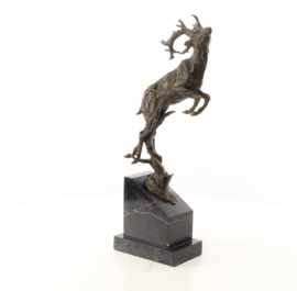 Een bronzen beeld van een springende hert