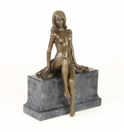 Een bronzen sculptuur van een deels naakte vrouw.