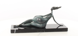 Een abstract bronzen beeld van een liggende naakte vrouw
